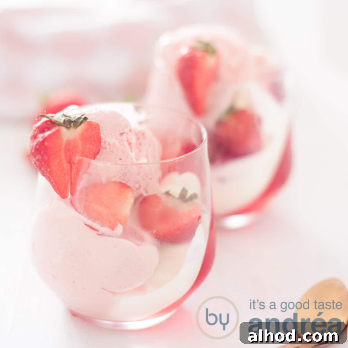Little Elves' Festive Feast 6 A square photo featuring two vibrant strawberry desserts, beautifully layered with ice cream, jelly, whipped cream, and garnished with fresh strawberries on a clean white background.