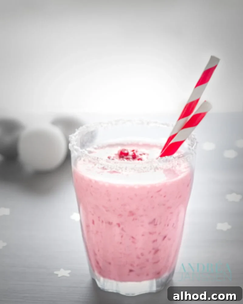 8 Delicious Smoothies to Power Your Healthy Morning 3 A vibrant red smoothie in a glass, garnished with pomegranate seeds and cranberries, with a subtle hint of coconut.
