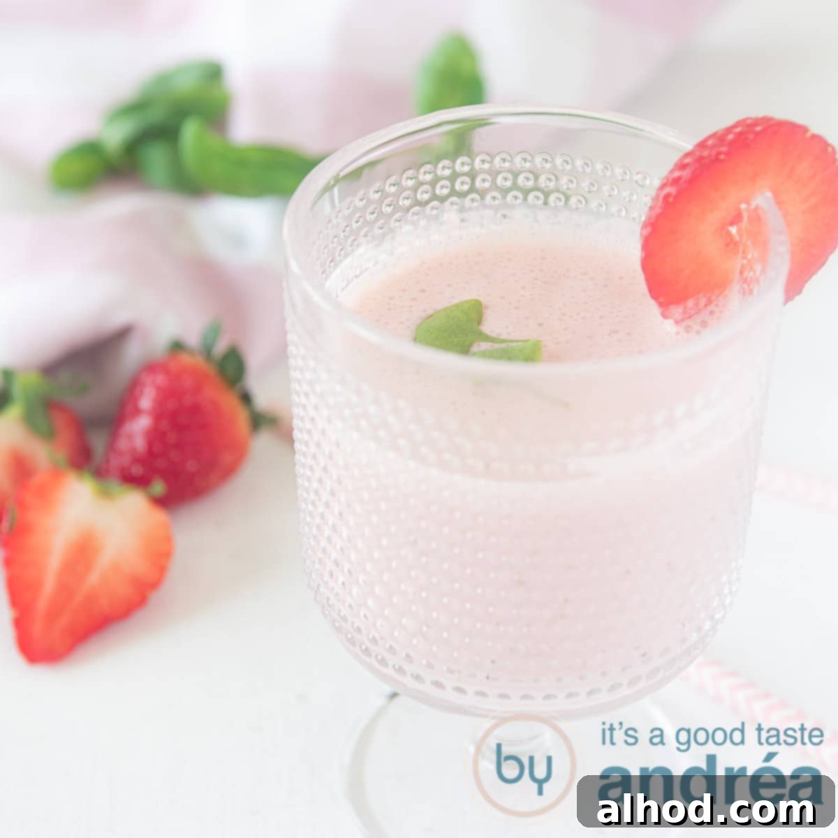 8 Delicious and Healthy Smoothies to Kickstart Your Day 5 a square photo with a glass filled with a smoothie with strawberries and basil