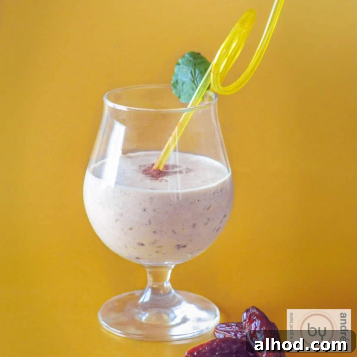 8 Delicious Smoothies to Power Your Healthy Morning 8 A square photo with a yellow background, featuring a tropical mango coconut smoothie with dates in the foreground, evoking a sunny, healthy vibe.