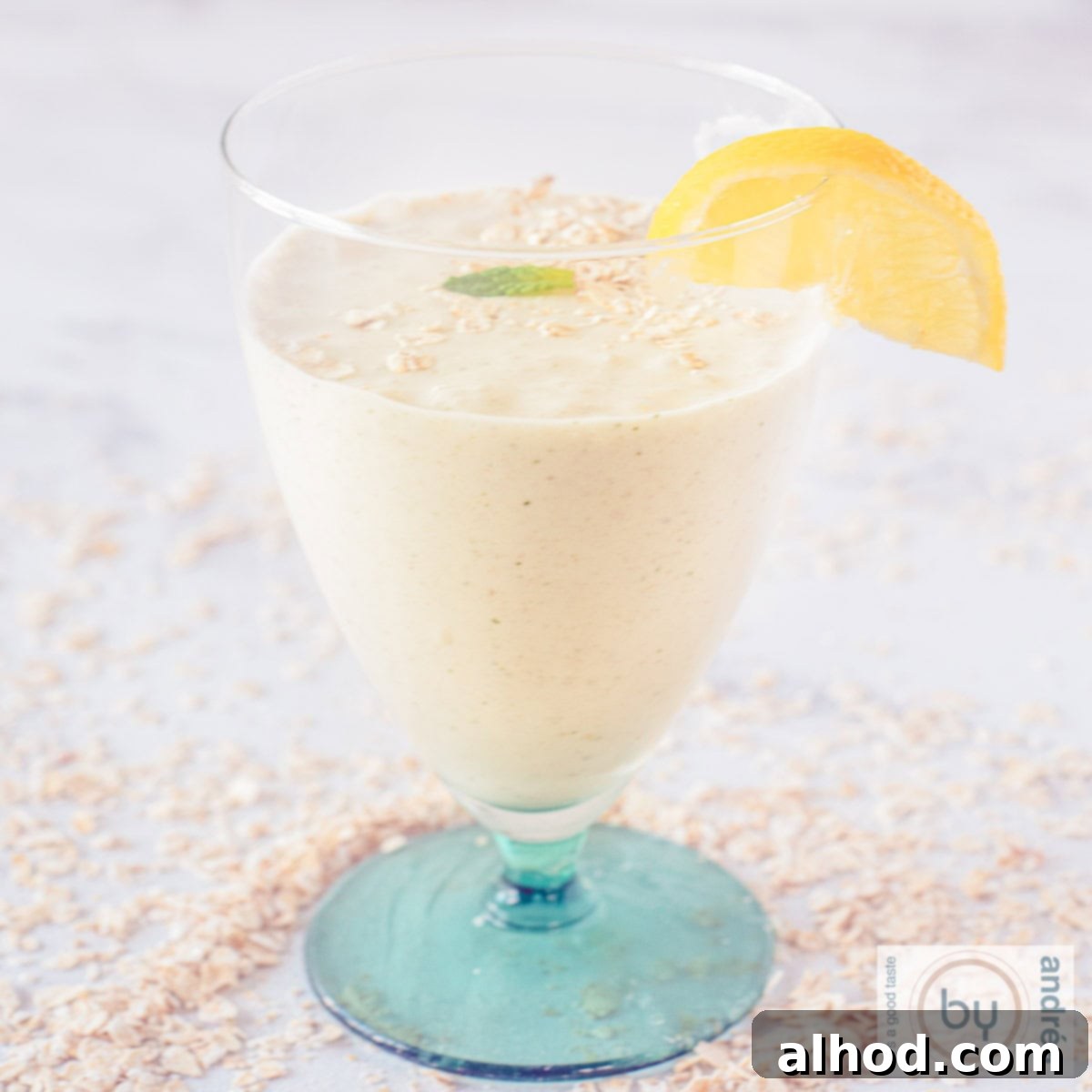 8 Delicious and Healthy Smoothies to Kickstart Your Day 9 A square picture with a glass with a green feet filled with banana oatmeal and mint.