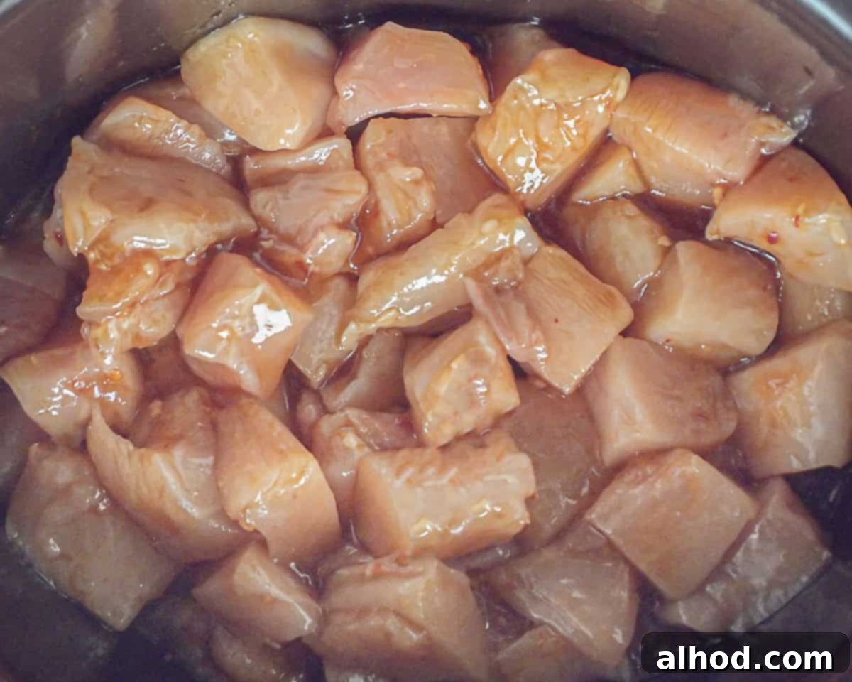 Easy Honey Garlic Slow Cooker Chicken 6 The slow cooker filled with chicken mixed with the sauce.