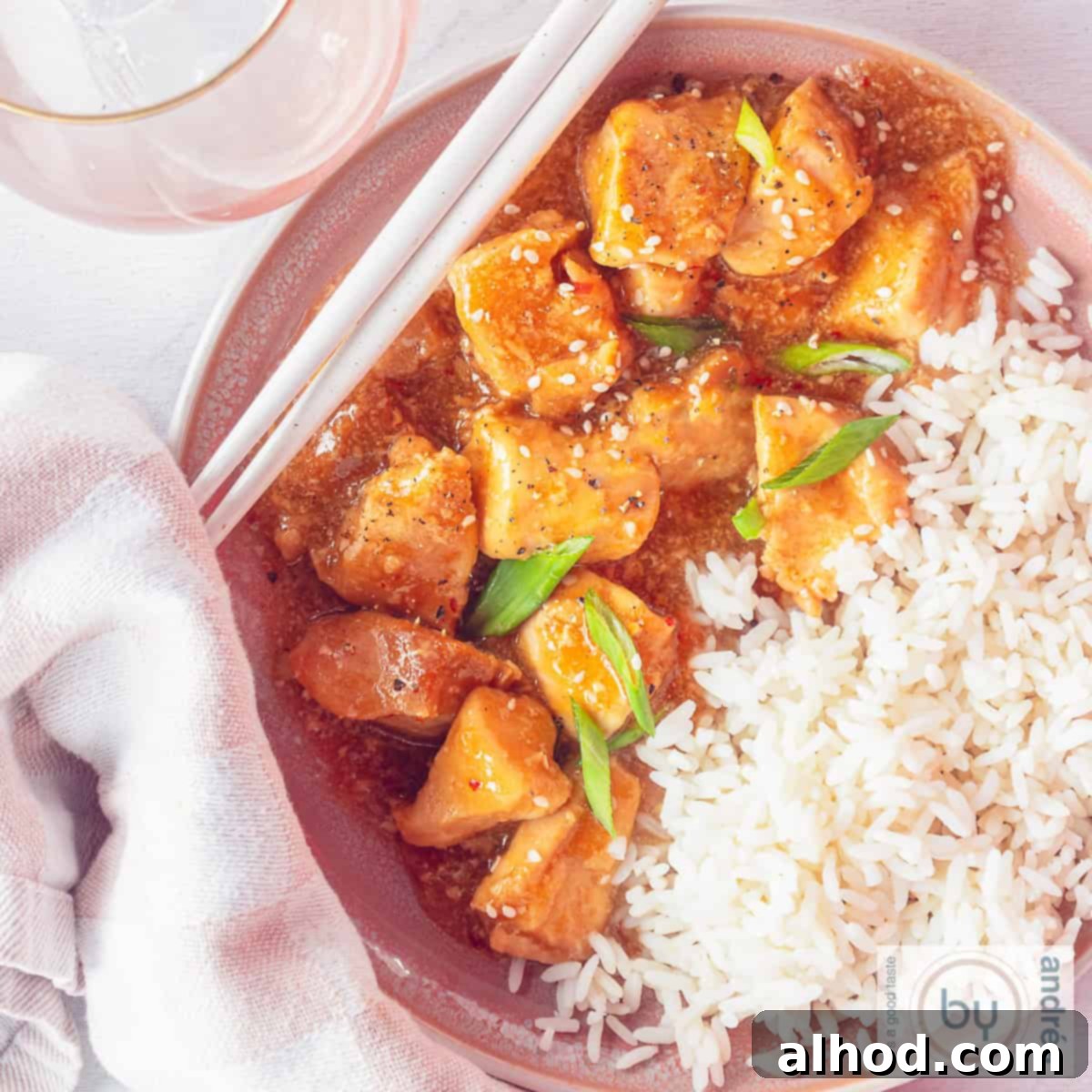 Easy Honey Garlic Slow Cooker Chicken 9 A square photo from above of a bowl half filled with honey garlic chicken and the rest with rice.