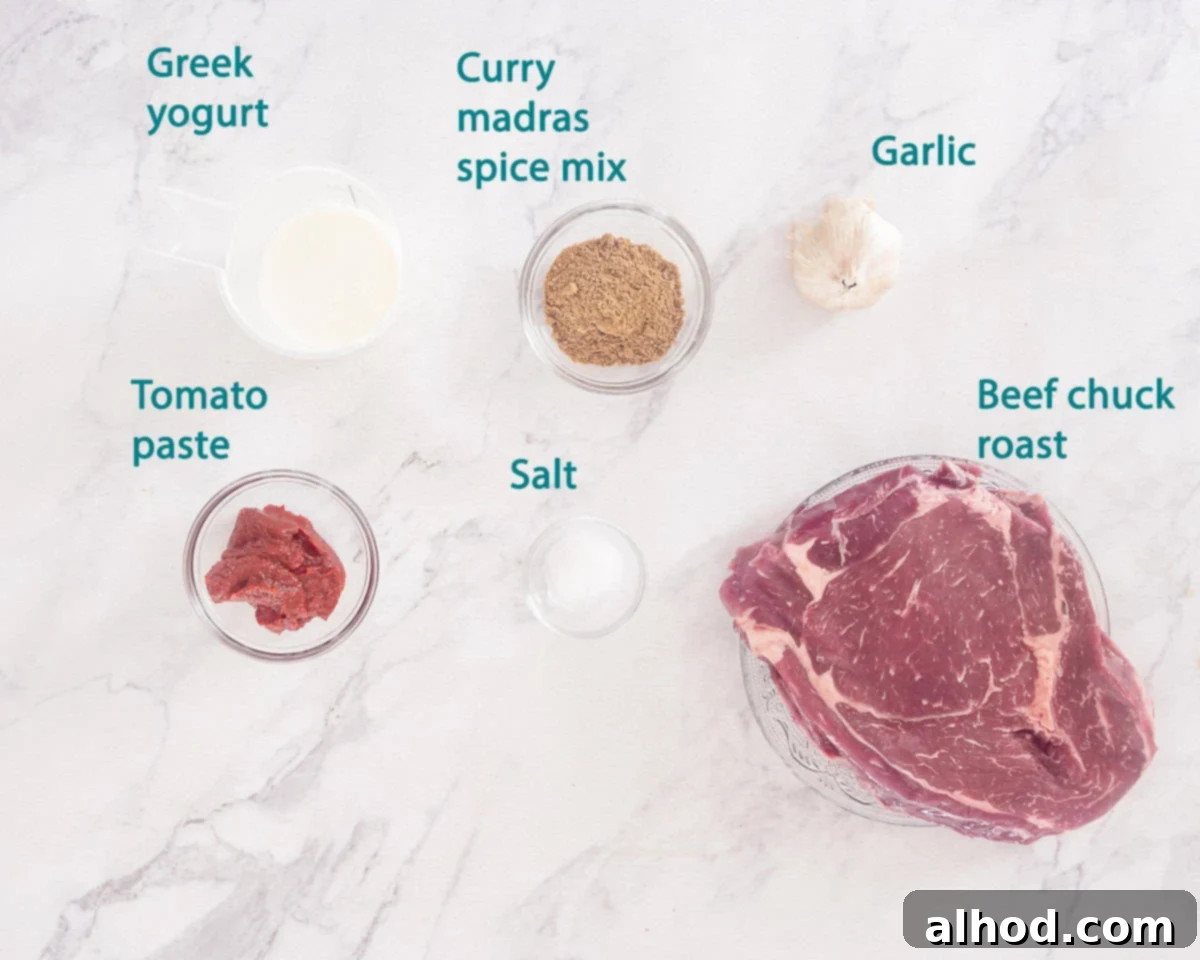 Tender Slow Cooker Beef Madras Curry 3 A curated display of ingredients for the curry madras marinade, including spices, yogurt, and tomato paste, arranged on a pristine white marble background with descriptive labels.