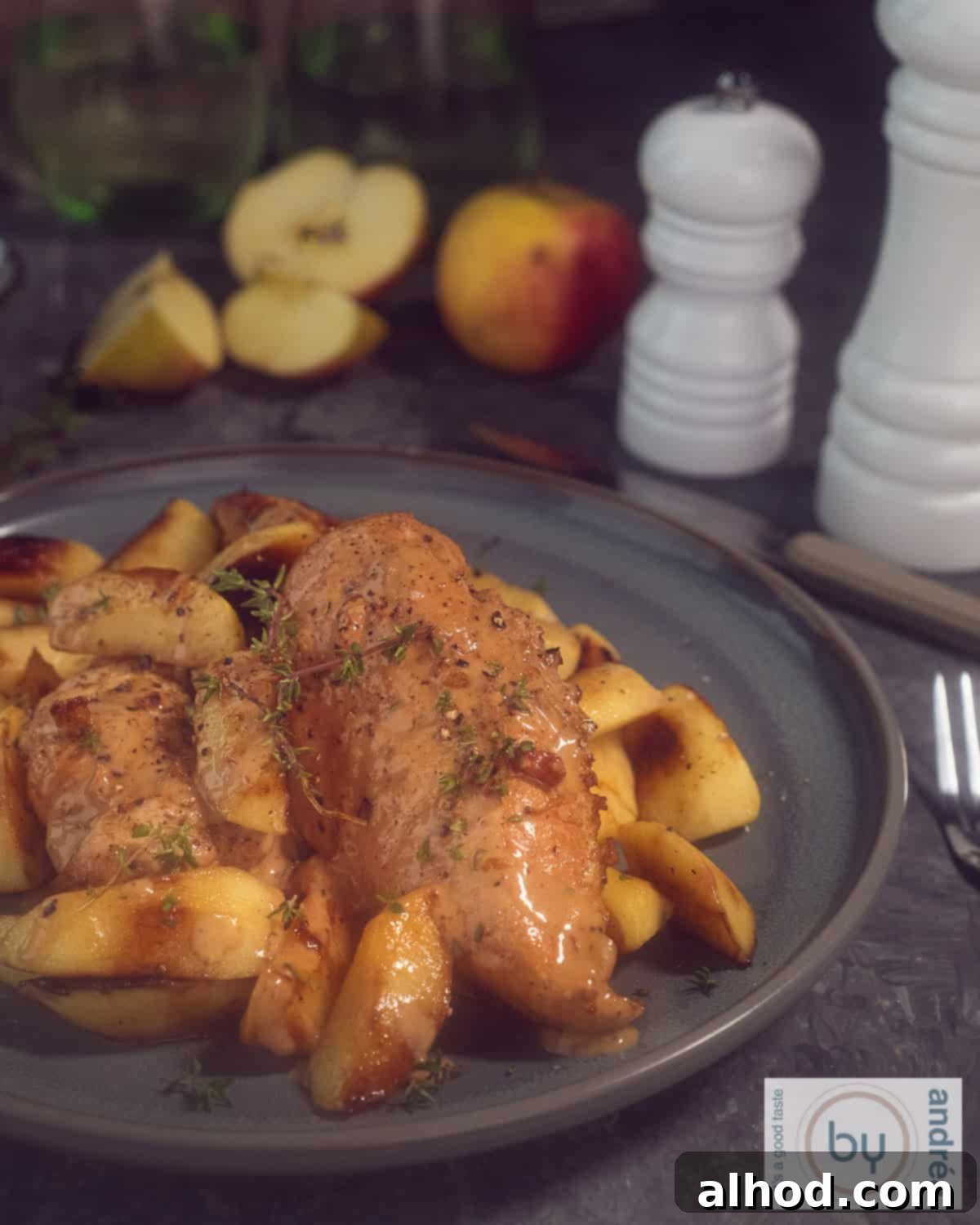 Rustic Norman Chicken with Apples and Cider 2 A gray plate with creamy Chicken a la Normande, garnished with sautéed apple slices and fresh herbs, ready to be served.