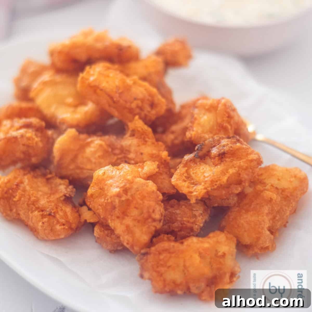Golden Kibbeling Bites – Holland's Favorite Fried Fish 4 A square photo of a white bowl with kibbeling.