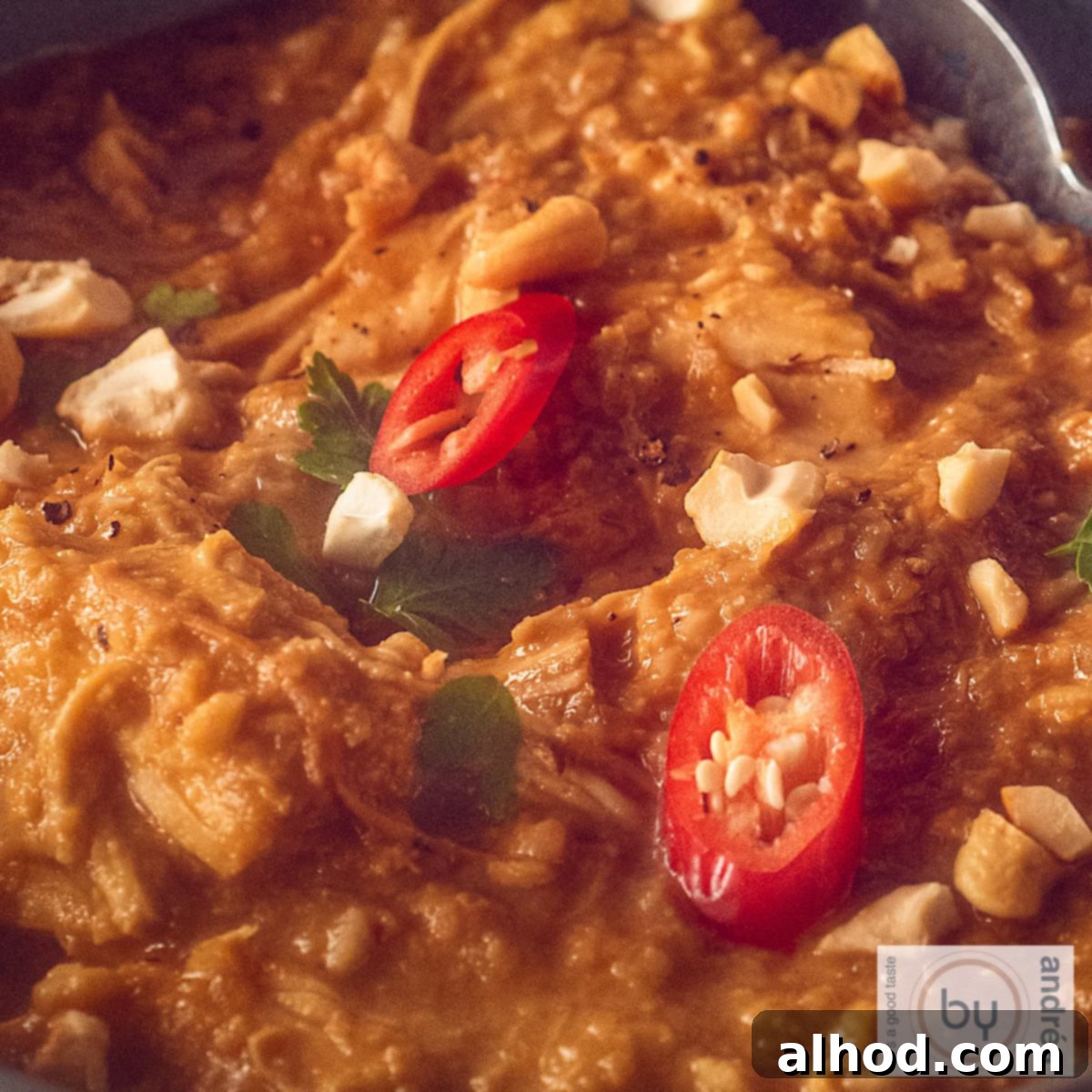 Creamy Slow Cooker Peanut Satay Chicken 4 Een deel van slowcooker pindakip met rode peper en koriander