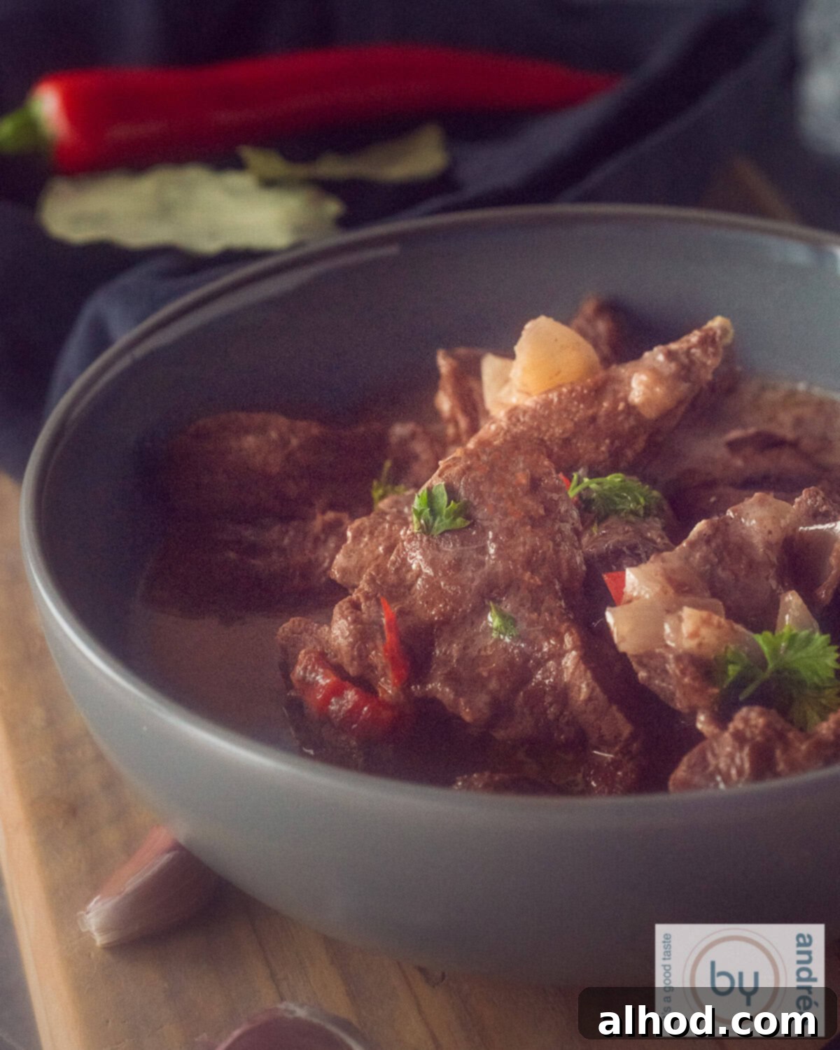 Melt-in-Your-Mouth Slow Cooker Beef Trinchado 2 A height photo of a gray bowl filled with Beef Trinchado from the slow cooker