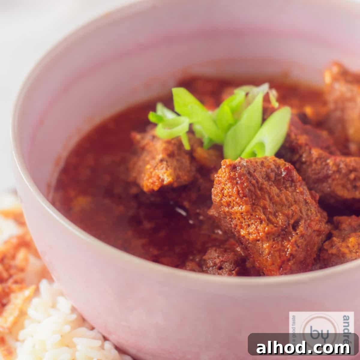 Creamy Slow Cooker Coconut Beef Curry 4 Beef curry with coconut milk in a pink bowl.