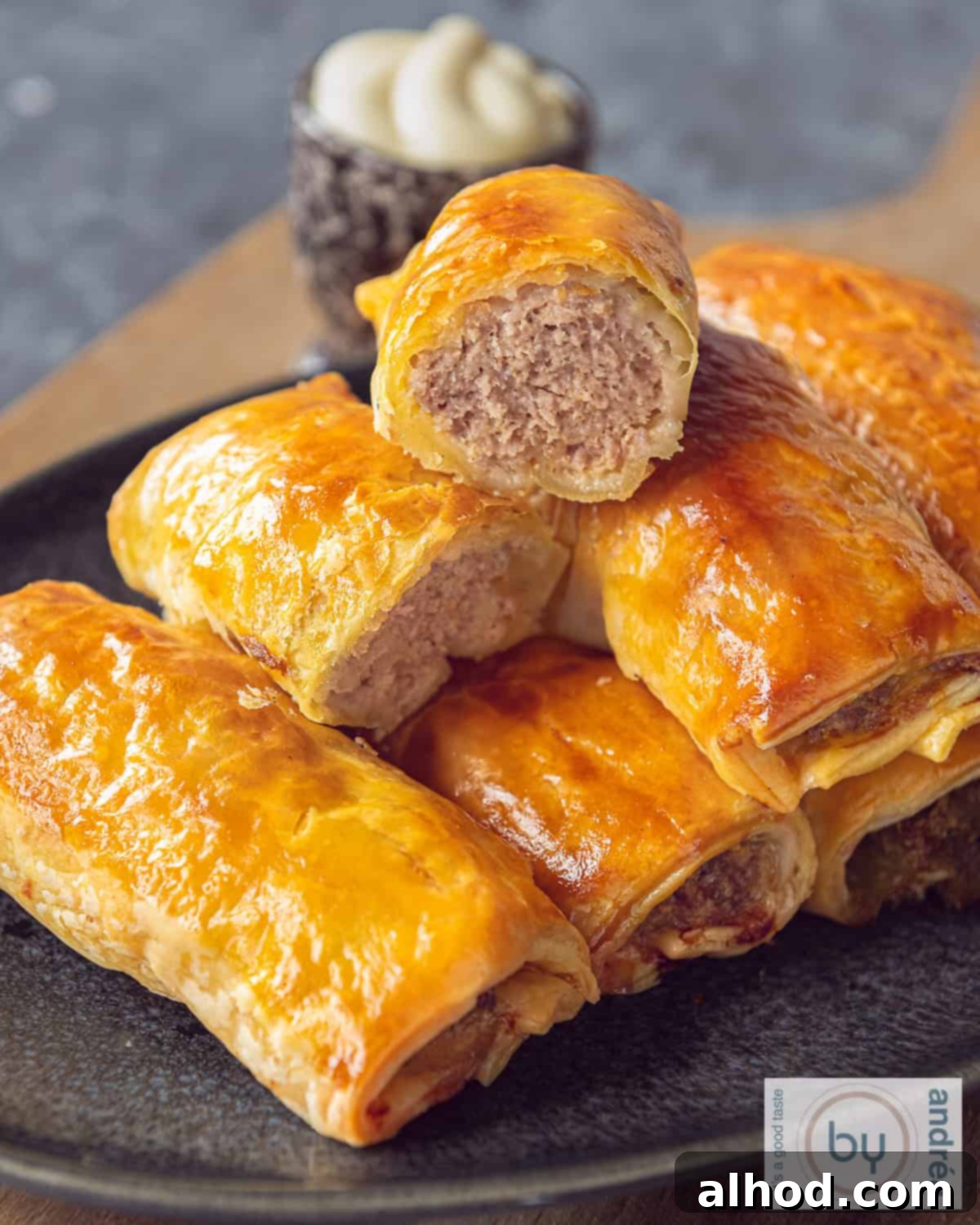 Flaky Dutch Sausage Rolls 2 A tray of sausage rolls, the top one halved, minced meat filling visible