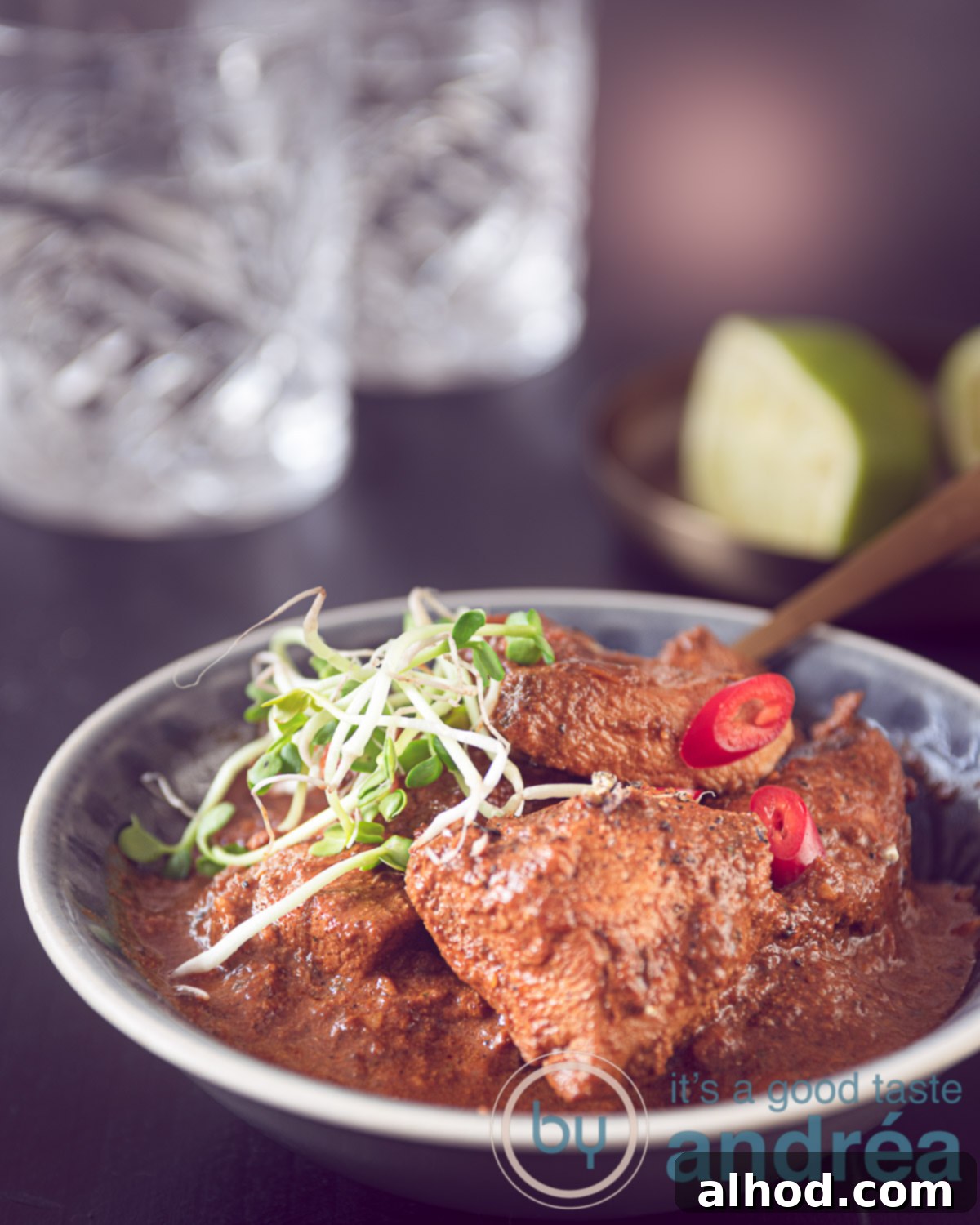 Chicken Tikka Masala A Culinary Masterpiece 2 Easy chicken tikka masala in a gray dish with some cress. A dark background with two glasses and squeezed lime