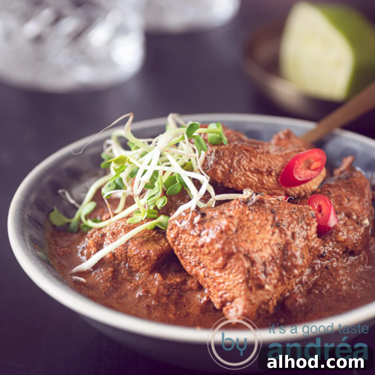 Chicken Tikka Masala A Culinary Masterpiece 3 a square photo of a grey bowl filled with Indian curried chicken on a black background