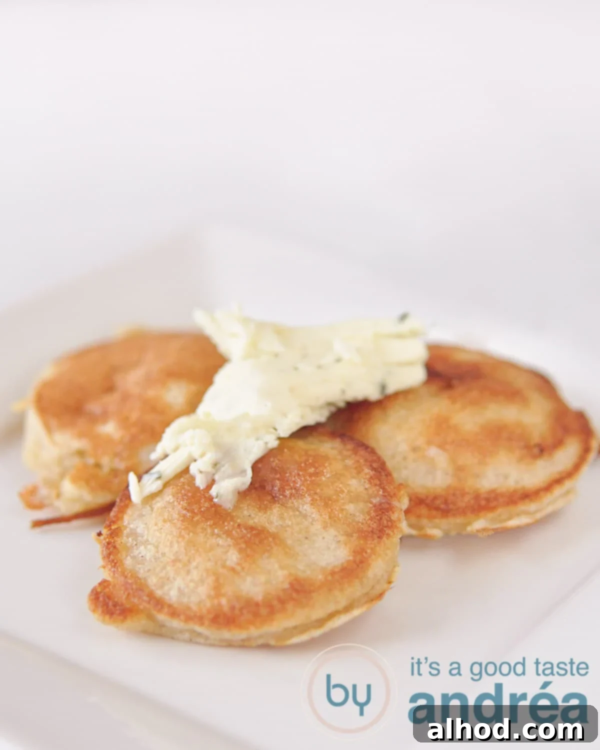Irresistible Cheese Fritters with Hand-Crafted Garlic Butter 3 Golden fritters with melting garlic butter on a white plate