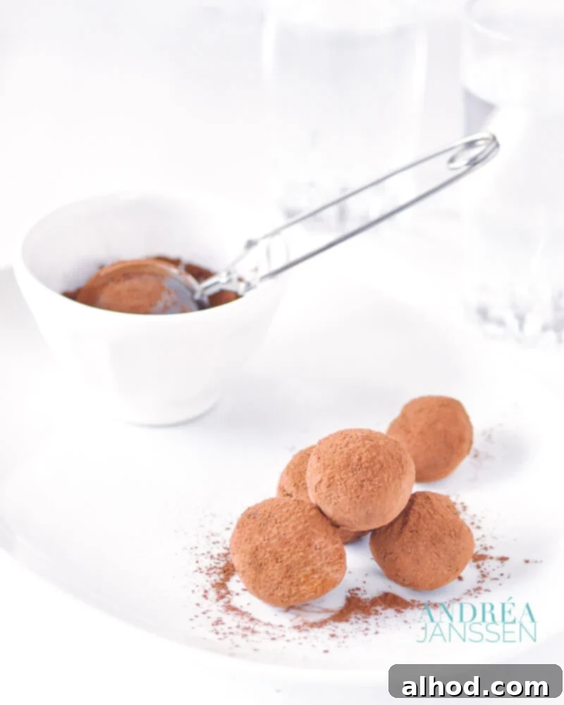 Velvet Orange Truffles 2 Orange chocolate truffles on a white plate with cocoa