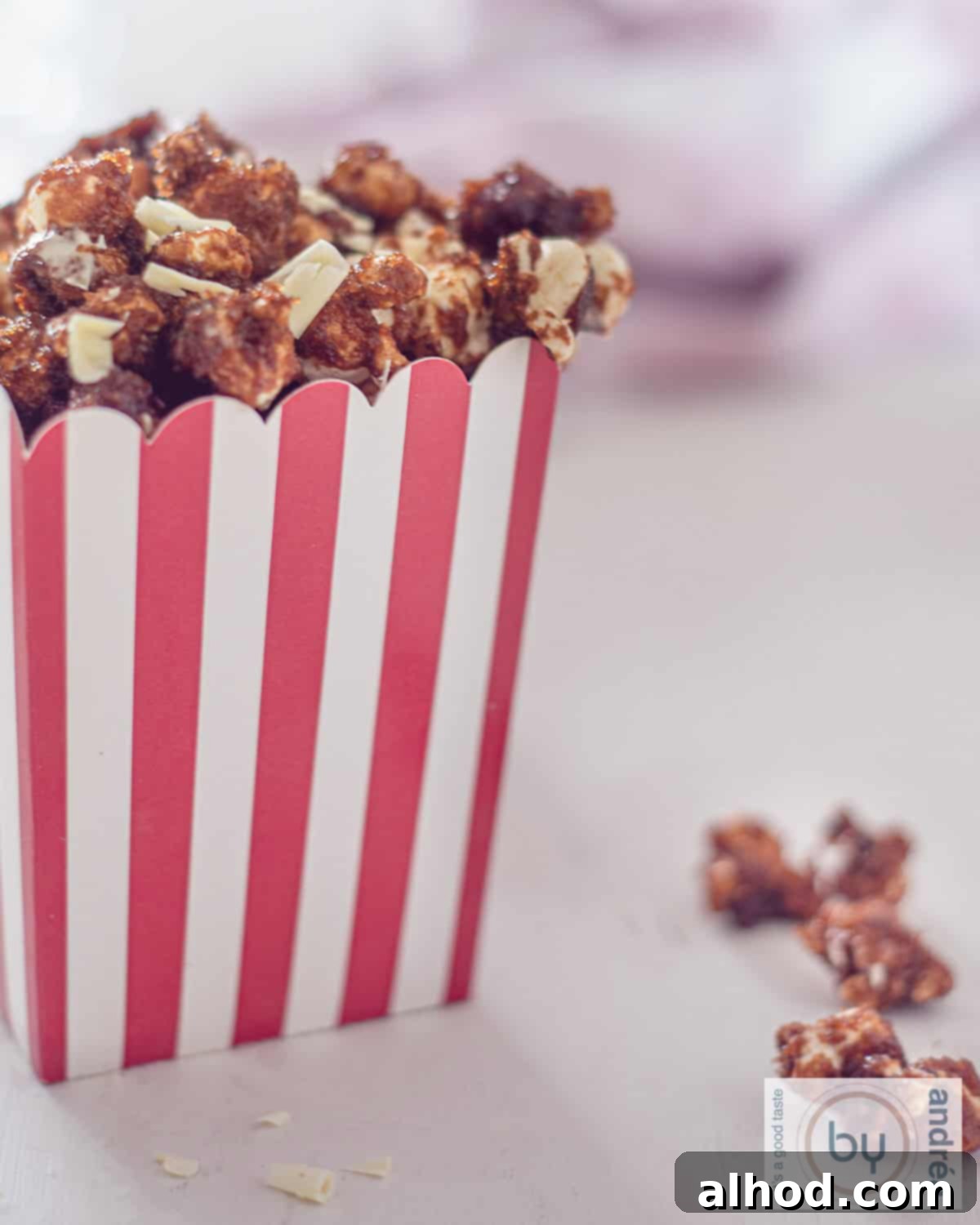 Gourmet White Chocolate Caramel Popcorn 2 A jar brimming with golden caramel popcorn, a refreshing drink, and two classic movie 3D glasses, setting the scene for a perfect movie night snack.