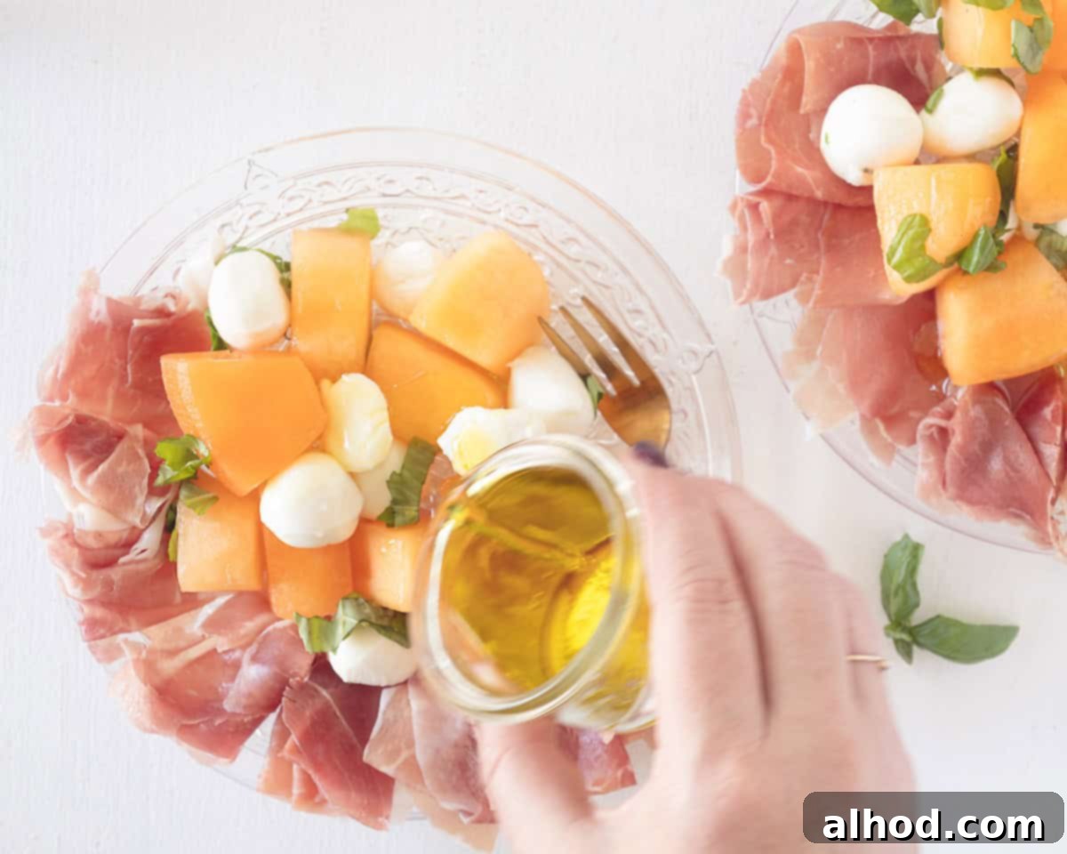 Vibrant Melon & Prosciutto Salad with Creamy Mozzarella 7 Olive oil is poured on top of the melon, mozzarella and parma ham salad