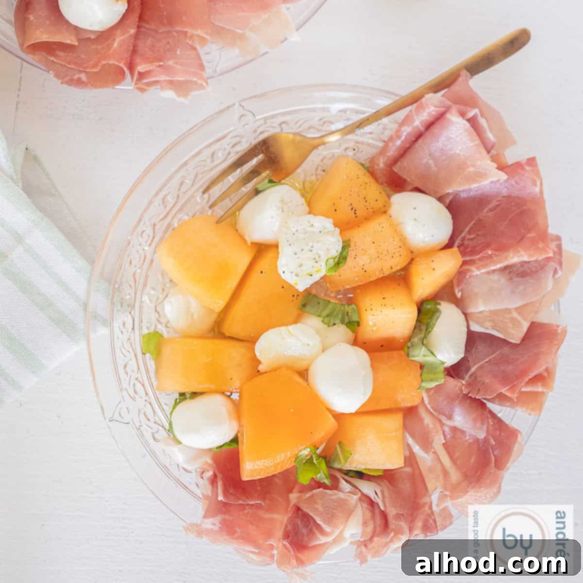 Vibrant Melon & Prosciutto Salad with Creamy Mozzarella 9 A square picture a glass plate with Parma ham, melon, mozzarella and basil.