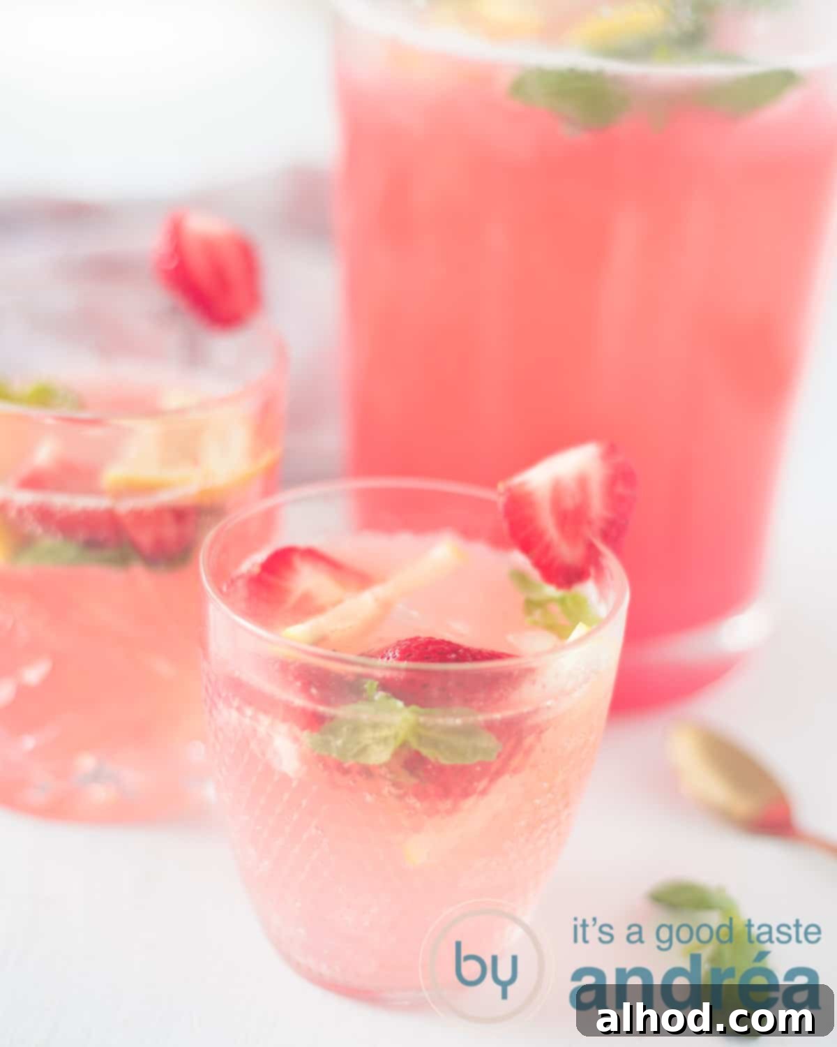 Strawberry Lemonade Mocktail with Basil 2 Refreshing strawberry basil lemonade mocktail served in two glasses with a pitcher in the background, perfect for summer.