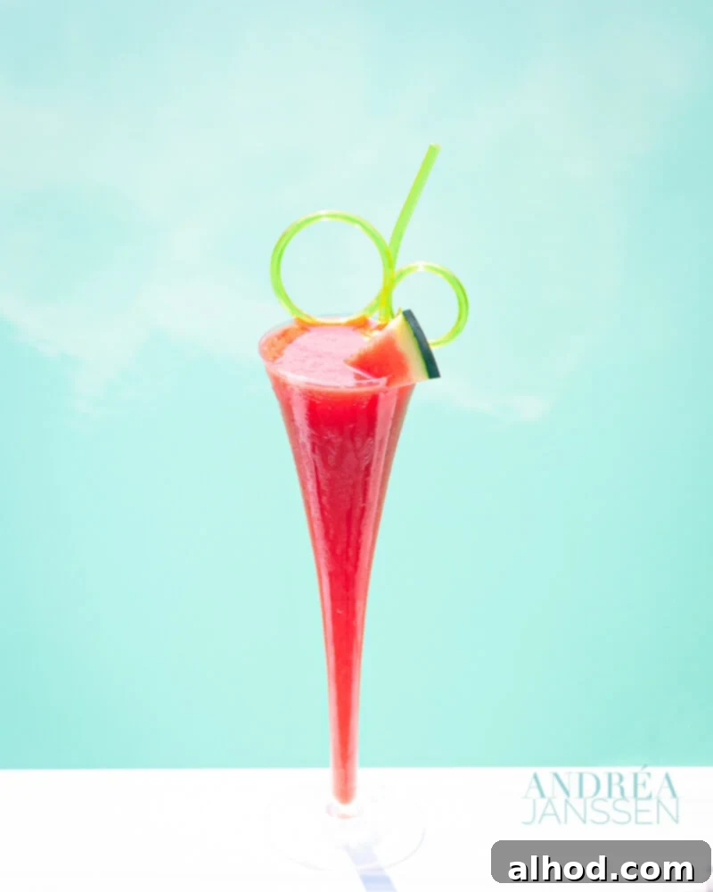 Crimson Chill 2 Watermelon slush in a glass with watermelon garnish and a blue swimming pool in the background