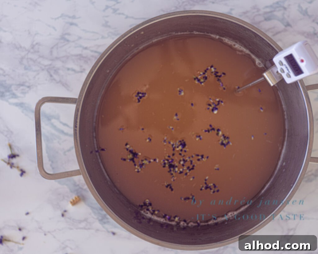Lavender Kissed Apple Jelly 6 Clear apple juice in a saucepan, with fresh lavender sprigs and other ingredients added, heating up to form the delicious jelly.