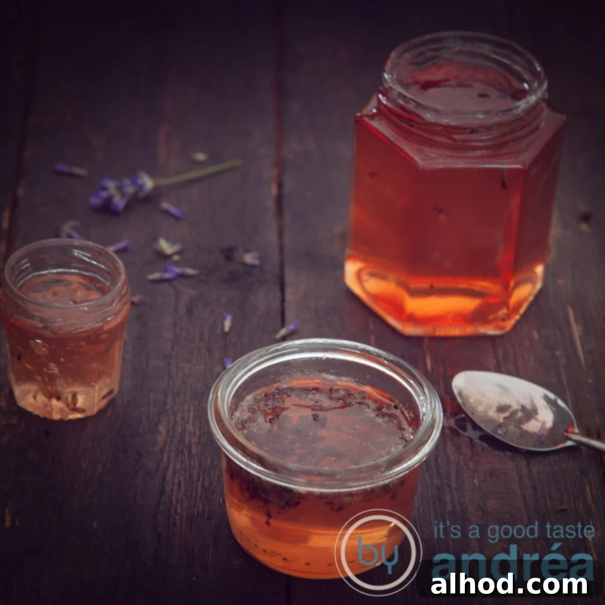 Lavender Kissed Apple Jelly 9 A square photo with 3 jars of apple jam on a dark background, showcasing the beautiful golden color of the homemade apple and lavender jelly.