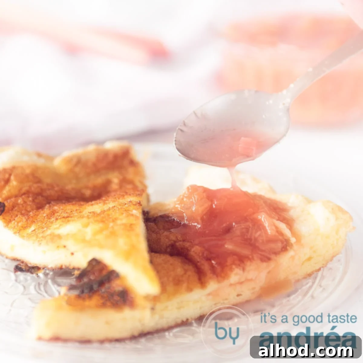 A square photo with two dots of sweet airy omelette with rhubarb compote. A spoon pours some rhubarb syrup on the omelette.