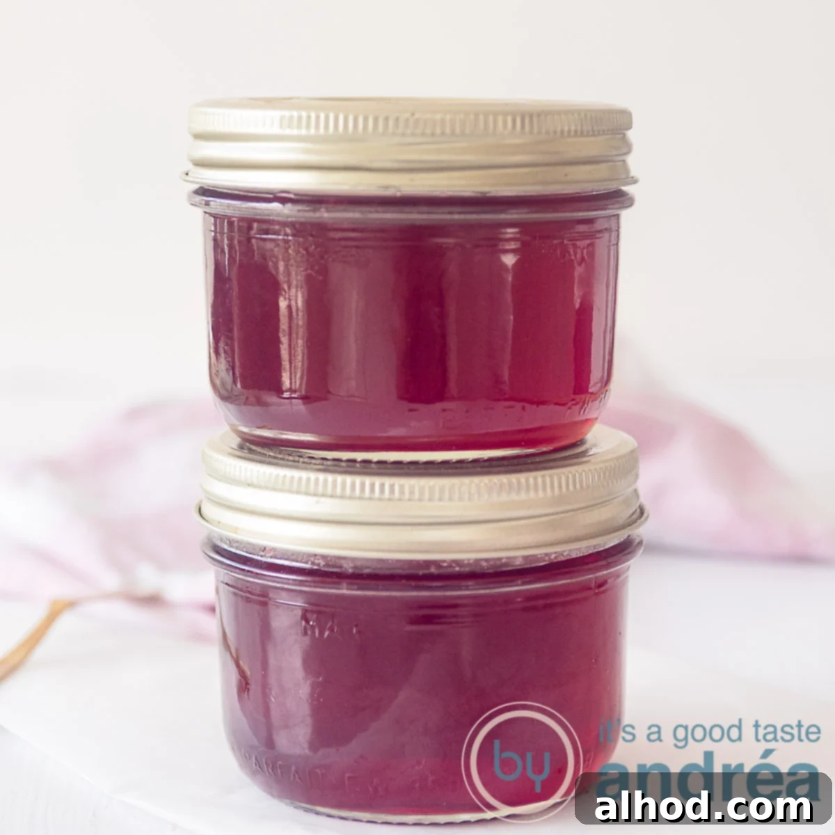Redcurrant jam with port wine, two jars on top of eachoter on a white background