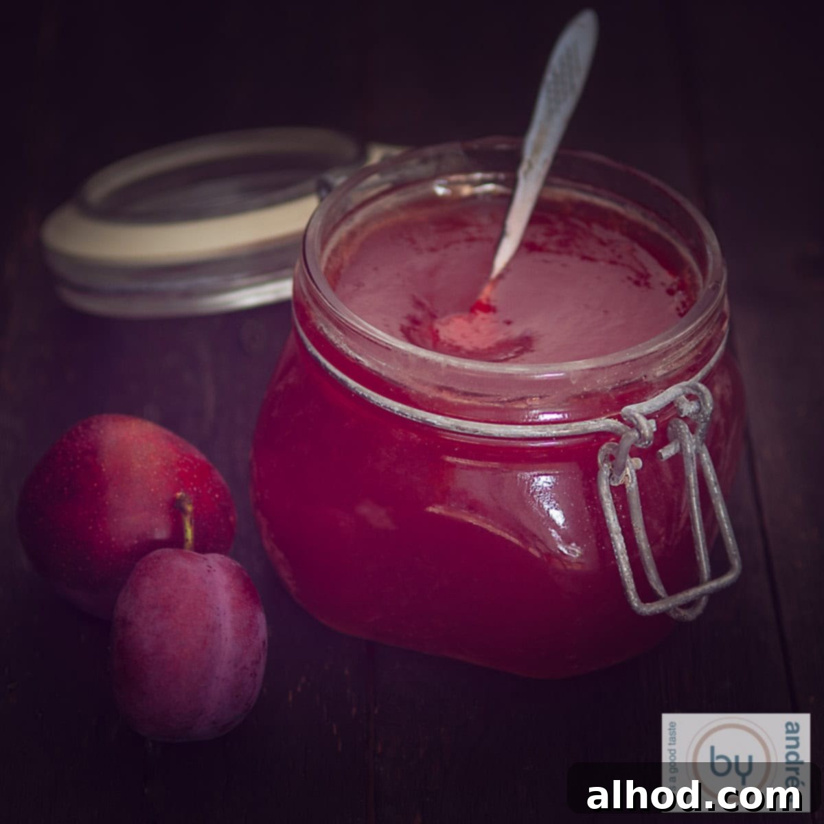 10 Irresistible Homemade Jam Recipes to Sweeten Your Day 8 Een vierkante foto van een pot pruimenjam met 2 pruimen aan de zijkant.