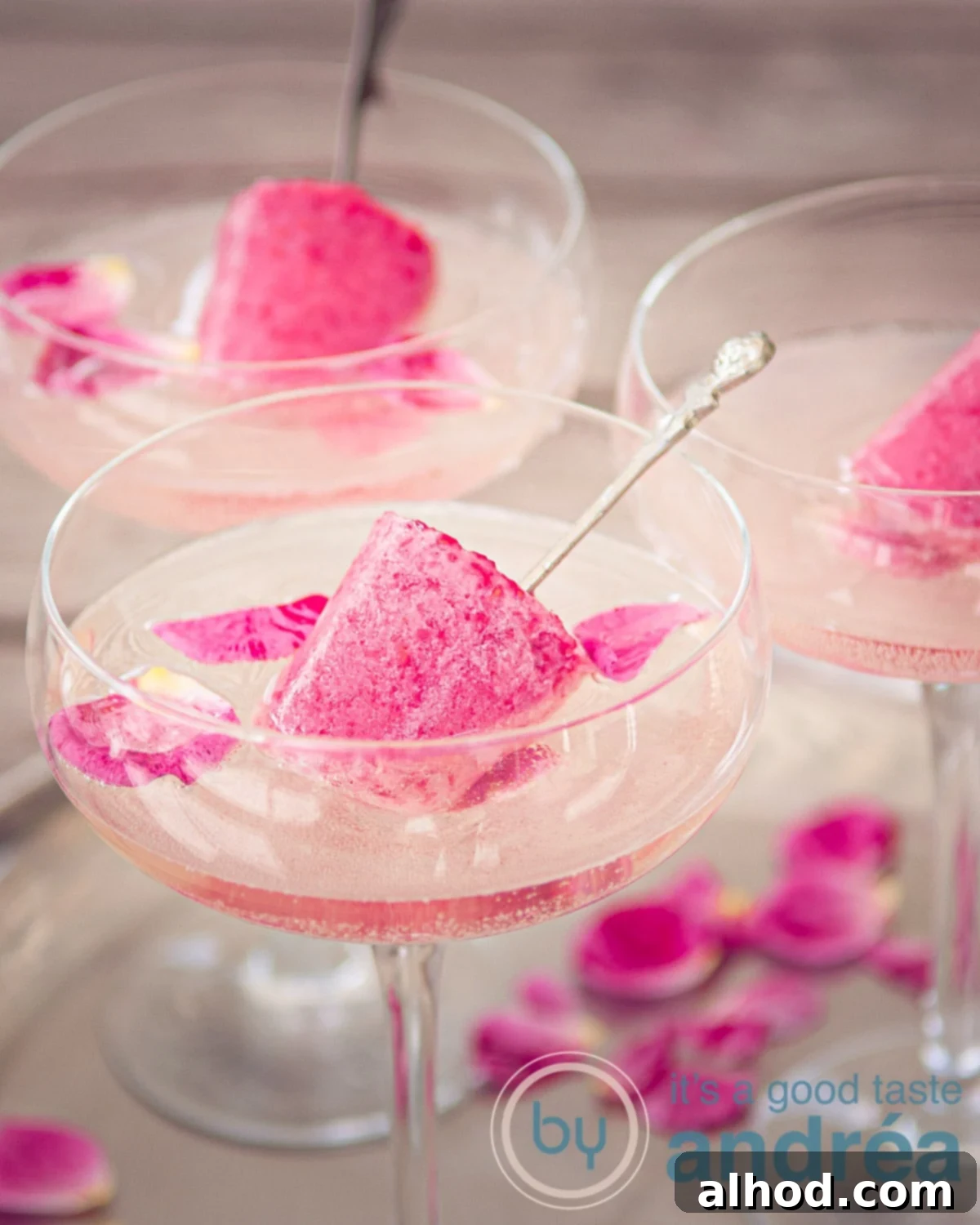 Sparkling Raspberry Pop Cocktails for Summer 3 3 champagne glasses with champagne, rose leaves and raspberry popsicle on a sliver plate