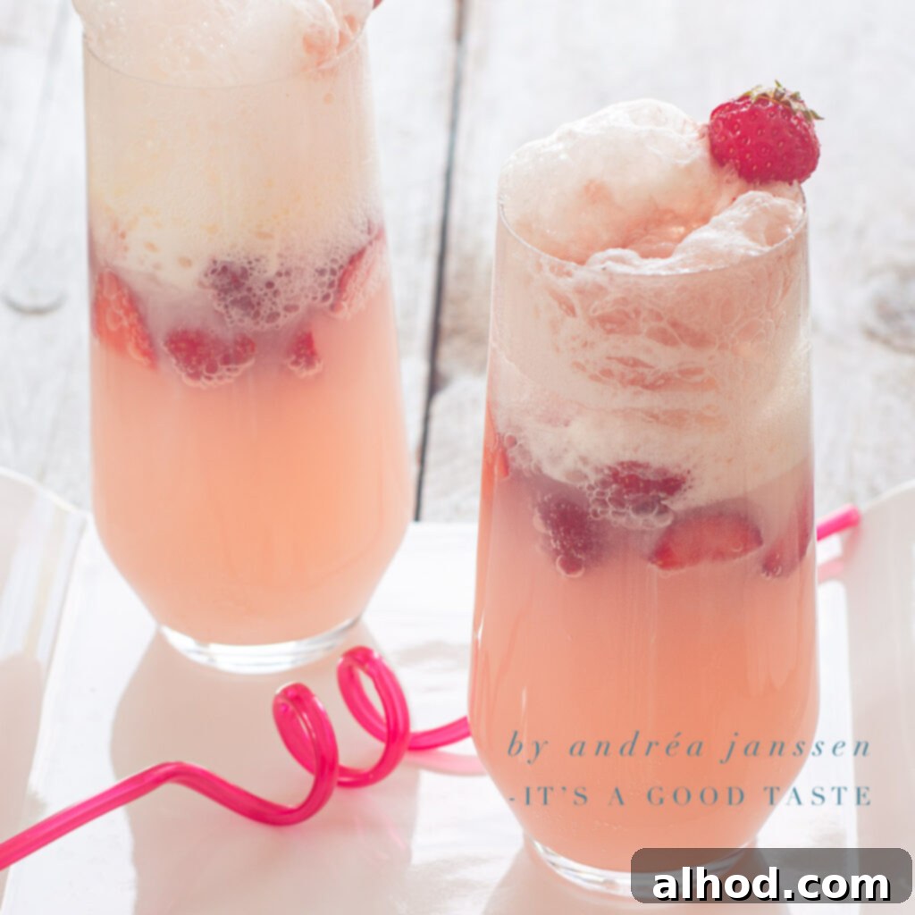 A square photo showing two glasses of vibrant strawberry ice cream soda, each topped with a scoop of vanilla ice cream and fresh strawberries, against a white background.