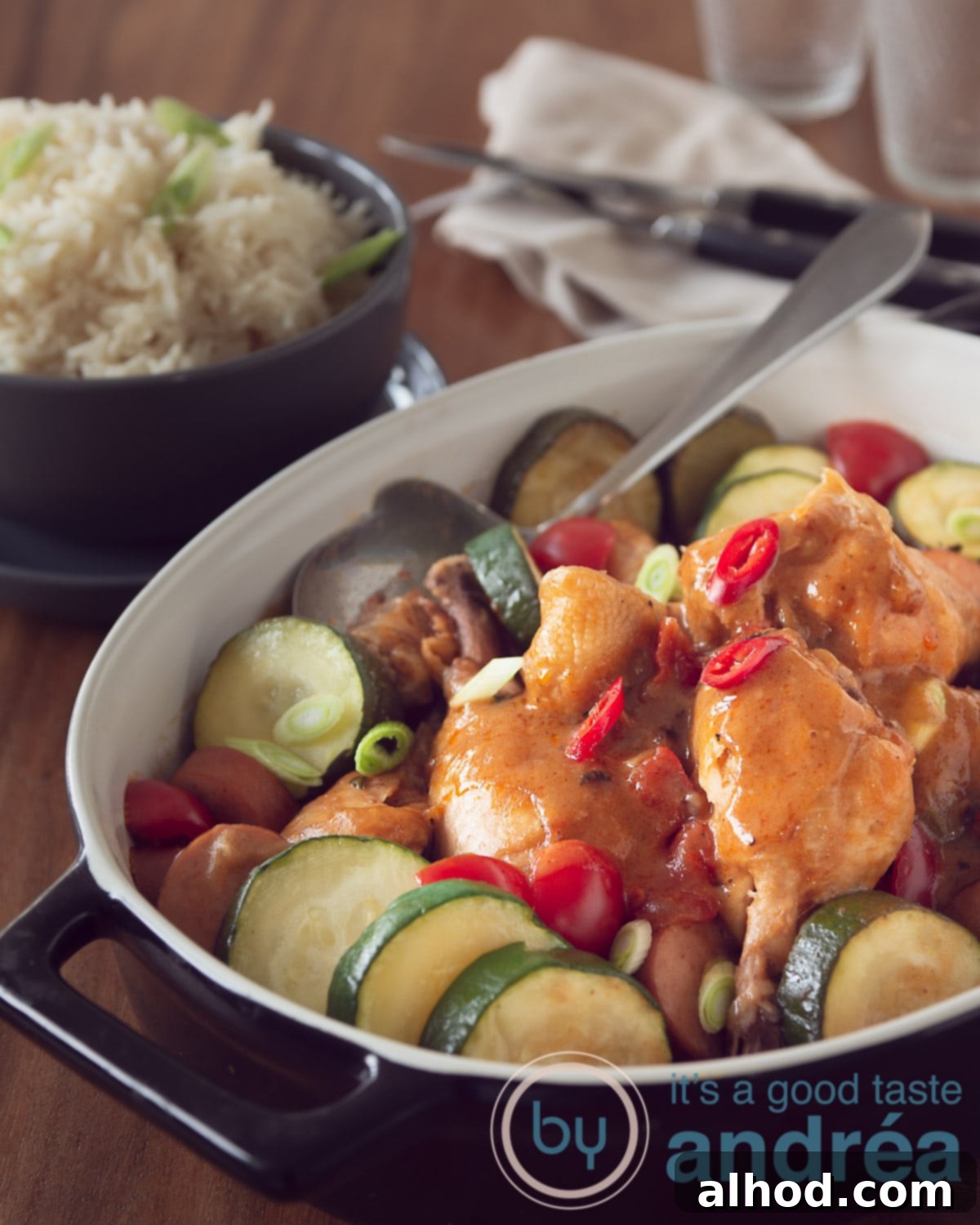 A black casserole dish filled with homemade gumbo with chicken and sausage, served hot and ready to eat.