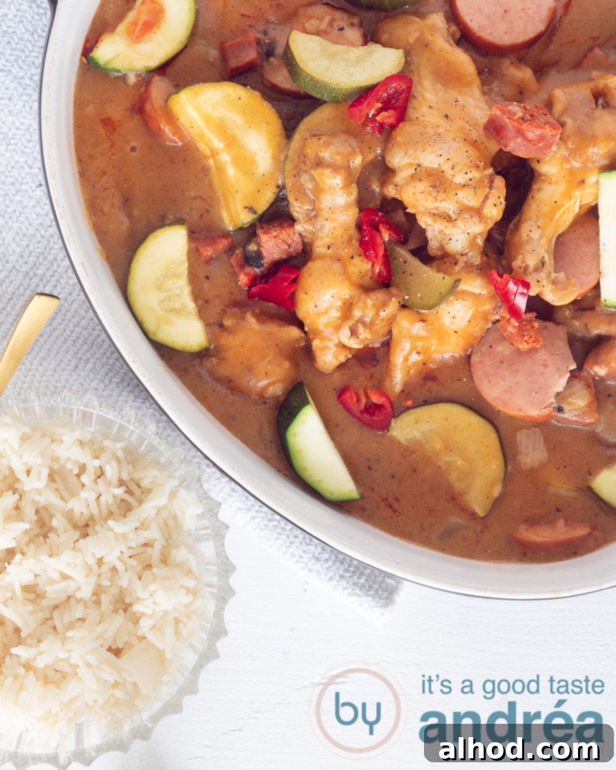 Soulful Cajun Chicken and Sausage Gumbo 3 A white casserole filled with gumbo and in the bottom Louisiana rice in a bowl, showcasing a complete and comforting meal.