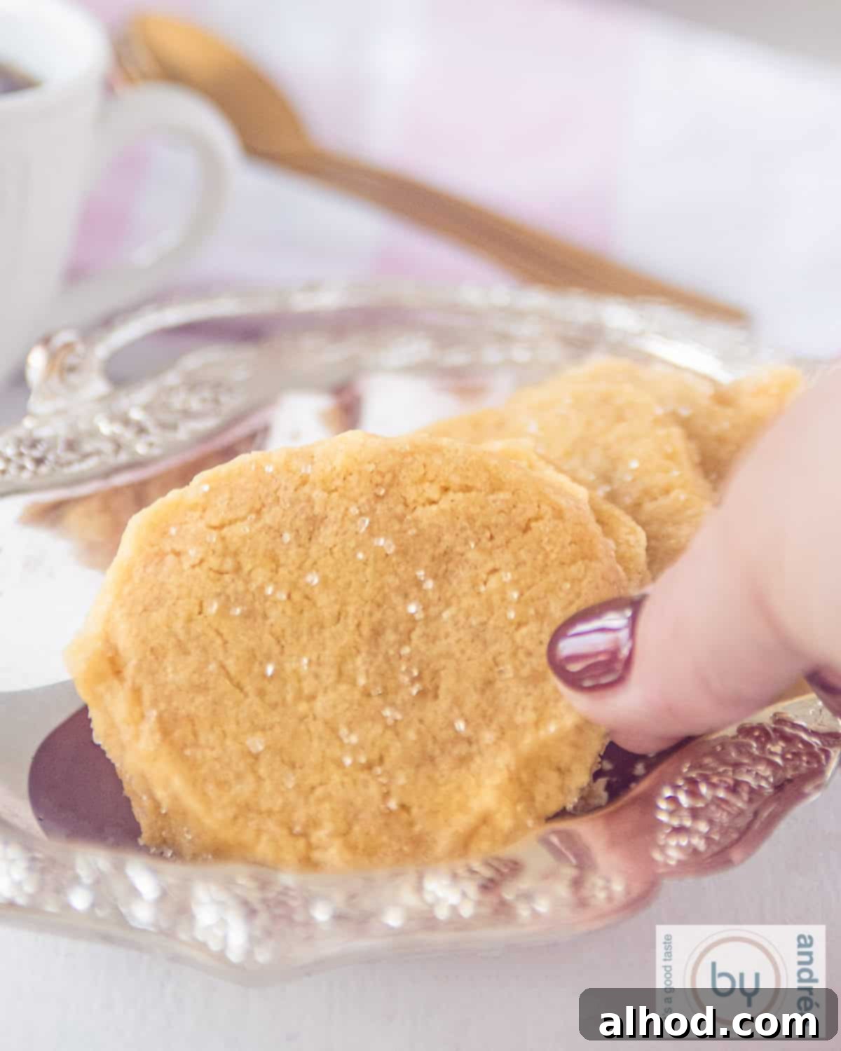 Crisp Ginger Shortbread Delights 2 Part of a silver platter with a row of gingerbread cookies. A hand takes a cookie.