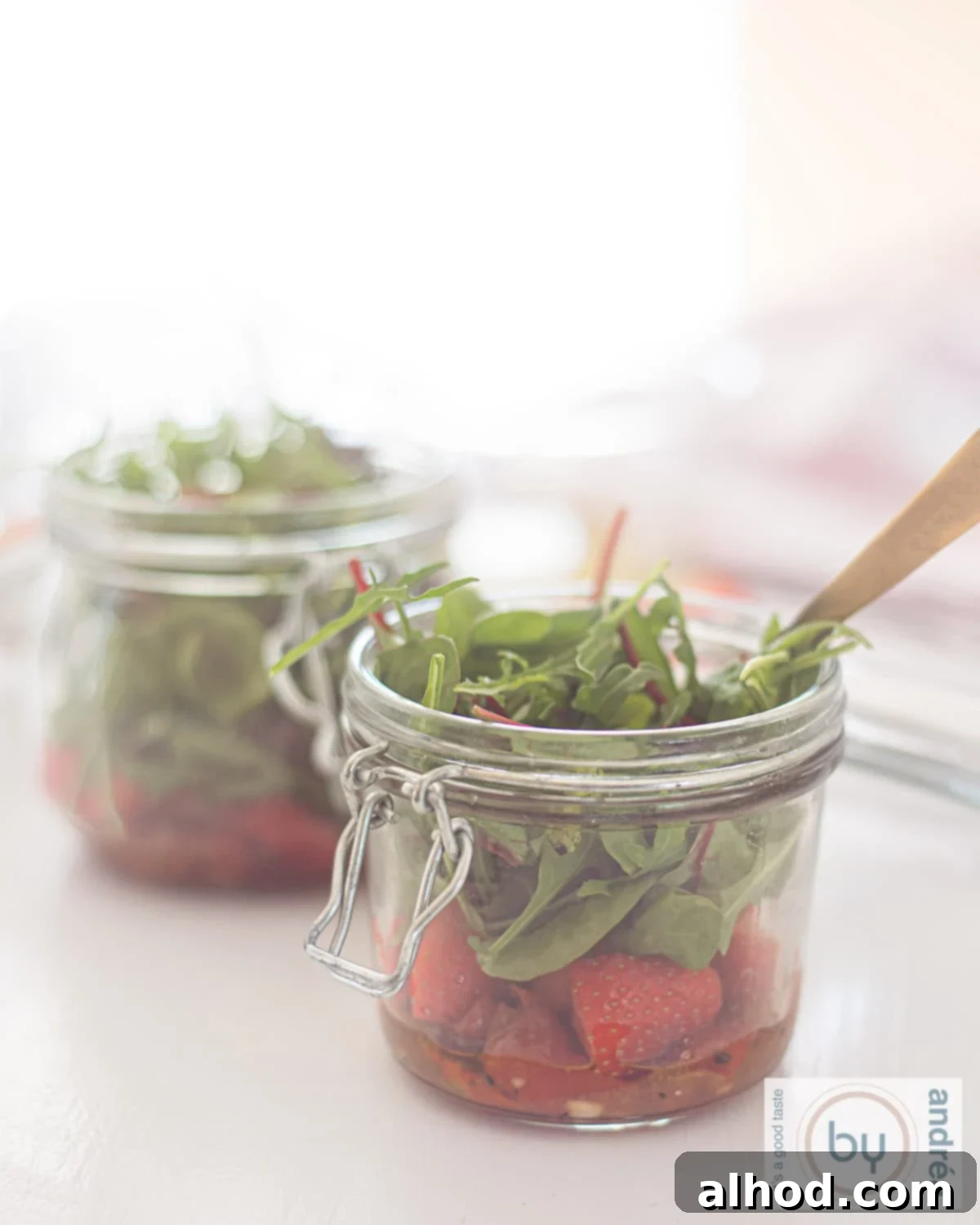 Sunshine in a Jar Salads 2 Two jars with a green salad, sun-dried tomatoes, strawberries, and a honey mustard dressing