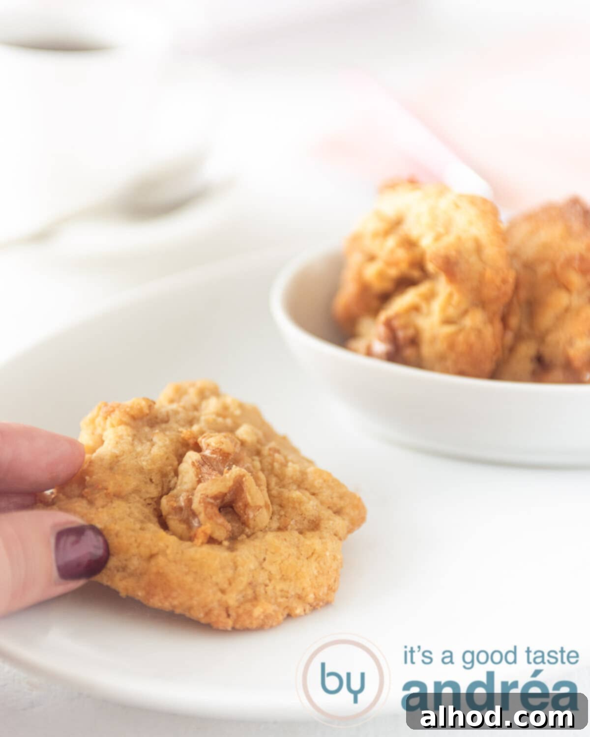 Homemade Walnut Cookies 2 Delicious walnut cookies with melted fudge on a white plate, ready to be enjoyed.