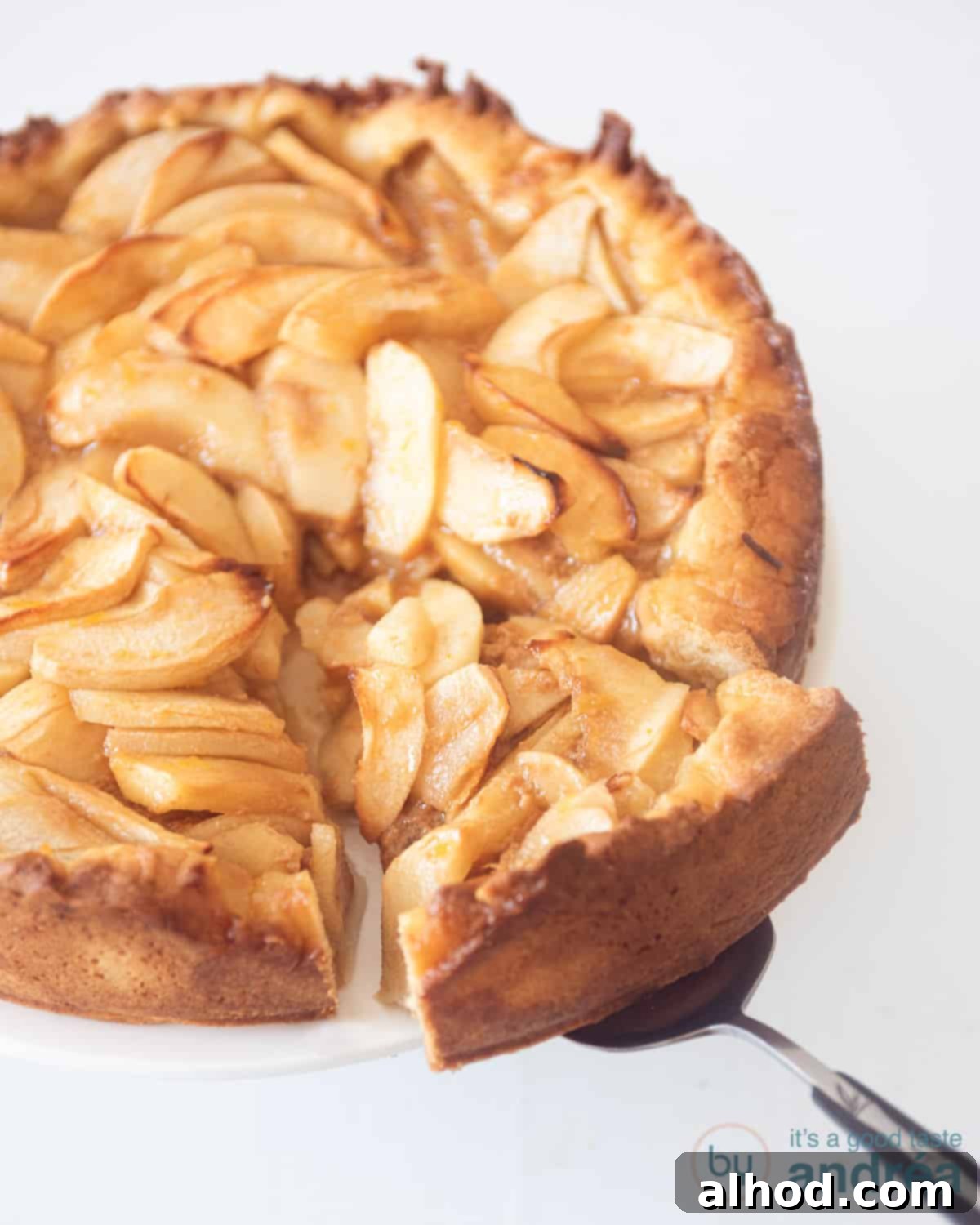 Golden Toffee Apple Pie 2 An apple pie with dulce de leche on a white surface. A cake server takes off a piece of the cake.