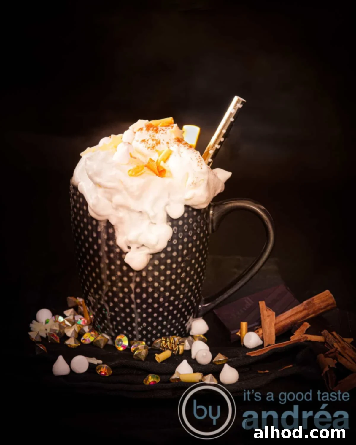 Velvet Licor 43 Hot Chocolate 2 A height shot of a black mug filled with creamy spiked hot chocolate with Licor 43, topped generously with marshmallows, gold accents, and a sprinkle of cinnamon.