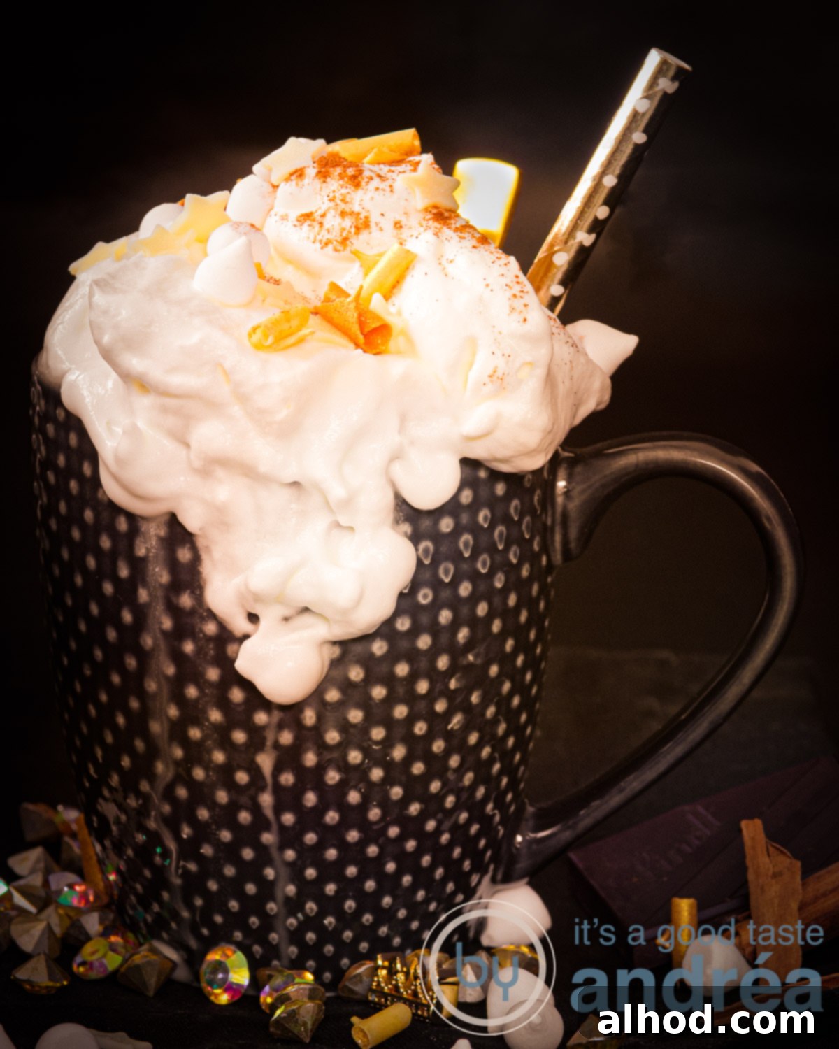 Velvet Licor 43 Hot Chocolate 5 A cup of Hot chocolate with vanilla and herbal liquor, garnished with gold accents and a cinnamon stick, set against a dark background.