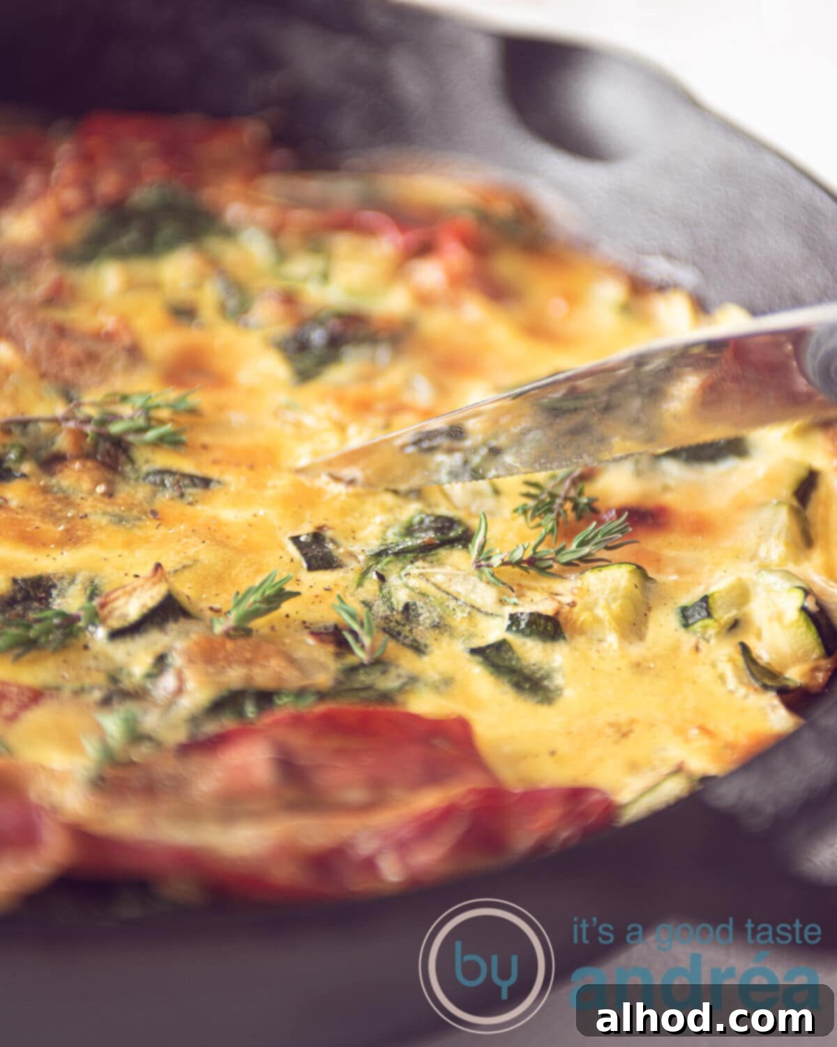 Fresh Zucchini and Spinach Frittata 2 A vibrant zucchini and spinach frittata, freshly baked and garnished, served in a cast iron pan, ready to be sliced for a delicious meal.