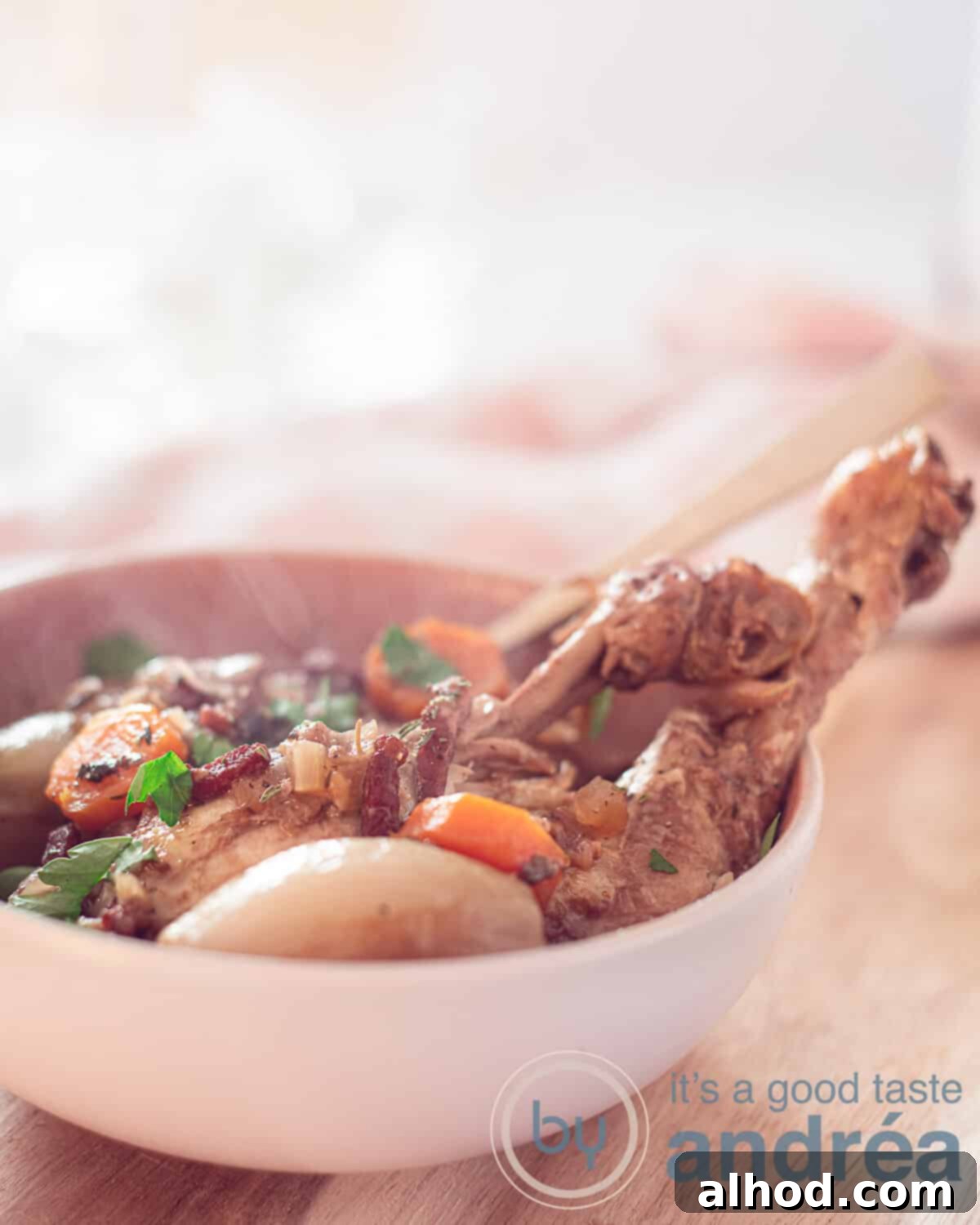 Classic French Red Wine Chicken 1 Coq au vin in a white pan on a wooden table, garnished with fresh parsley.