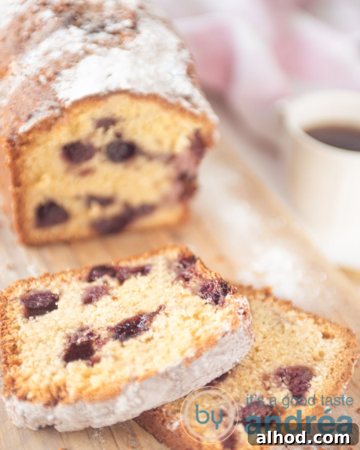 Tangy Blueberry Yogurt Cake 5 A rustic wooden board featuring a delicious blueberry cake with two slices already cut, ready to be served. A cozy cup of coffee sits to the right, completing the perfect breakfast or snack scene.