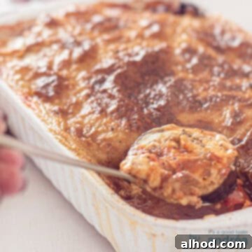 Greek Buffet Bliss: 9 Recipes, Timed for Success 6 A square picture of a white casserole filled with Eggplant Moussaka. A spoon taking out some food.