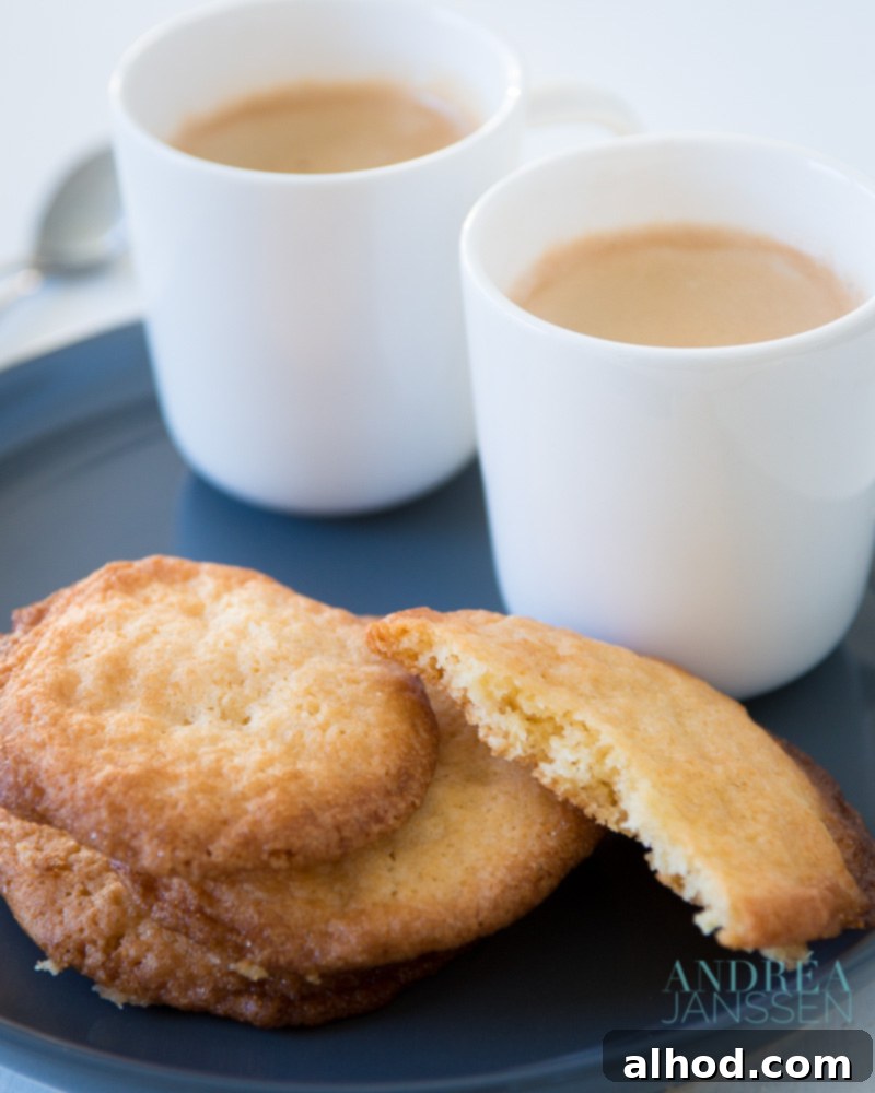 10 Ultimate Cookie Recipes You Have to Try 4 A plate of golden-brown, easy-to-bake cookies, each glistening with a crunchy sugar coating, paired with a cup of freshly brewed coffee, perfect for a simple pleasure.