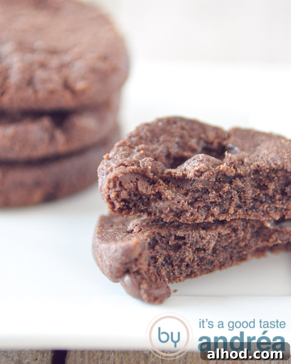 A delicious arrangement featuring two halves and a small pile of famous World Peace cookies, highlighting their rich, dark chocolate interior and crumbly texture.