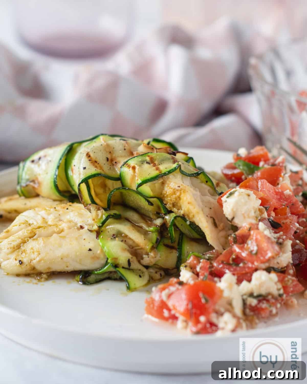 Golden Tilapia with Fresh Tomato Feta Salad 2 Tilapia fillet, fried, with tomato salad on a white plate