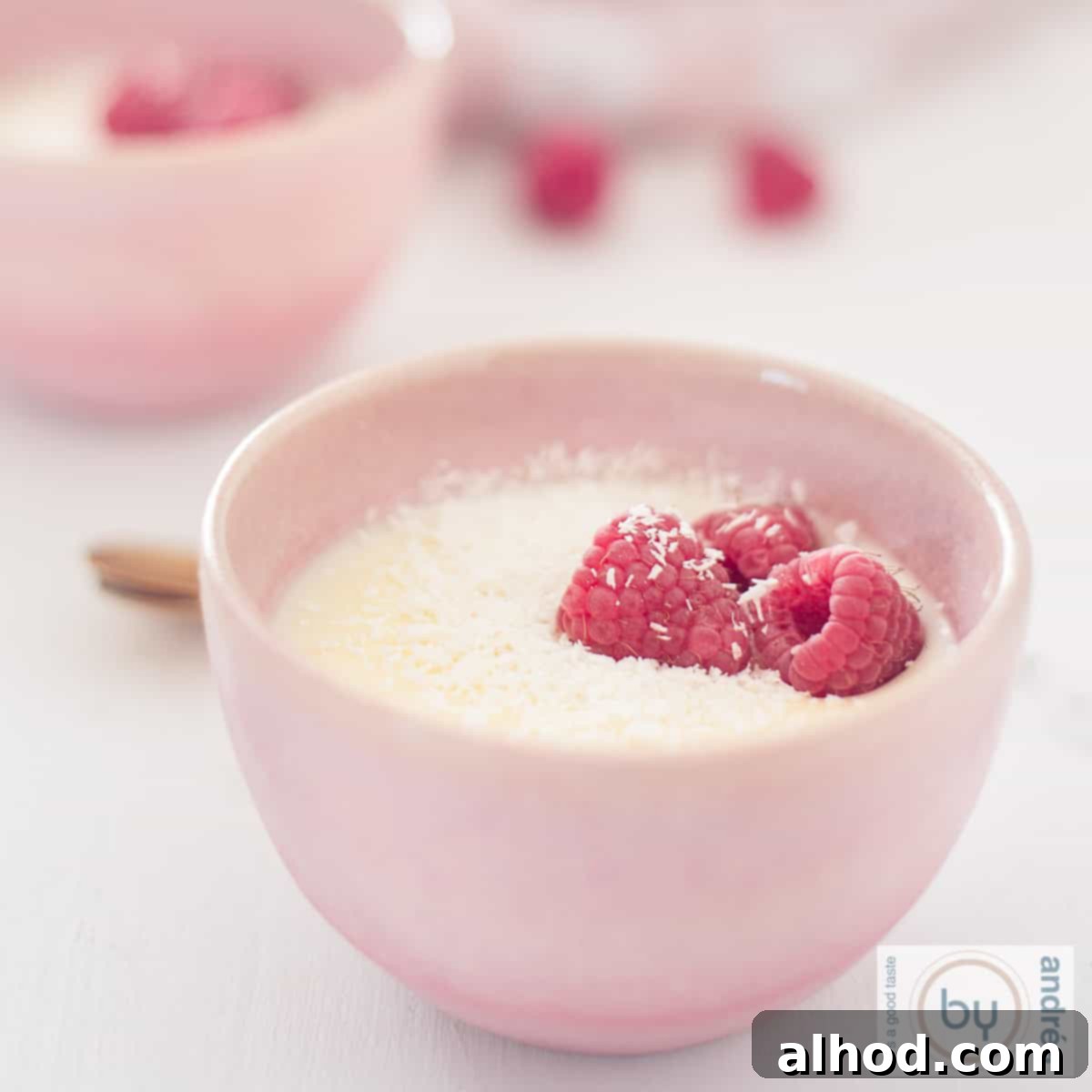 Easy 3-Ingredient Creamy Lemon Custard 9 A square photo with two pink bowls of creamy lemon custard with raspberry
