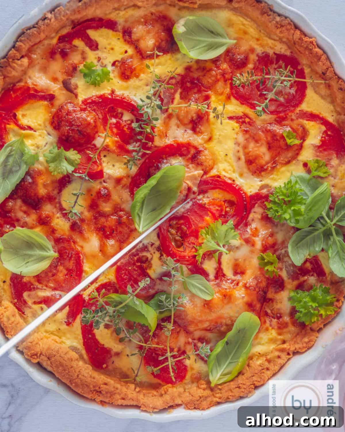 Savory Tomato Brie Quiche with Garden Herbs 3 A top-down photo of a quiche with tomato, brie and fresh herbs