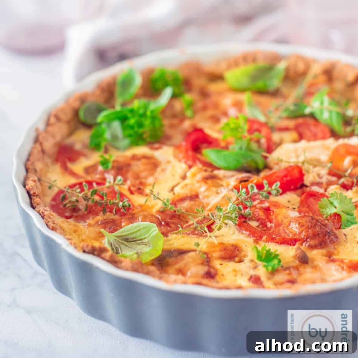 Savory Tomato Brie Quiche with Garden Herbs 4 A square photo of a quiche with tomato, mustard and brie
