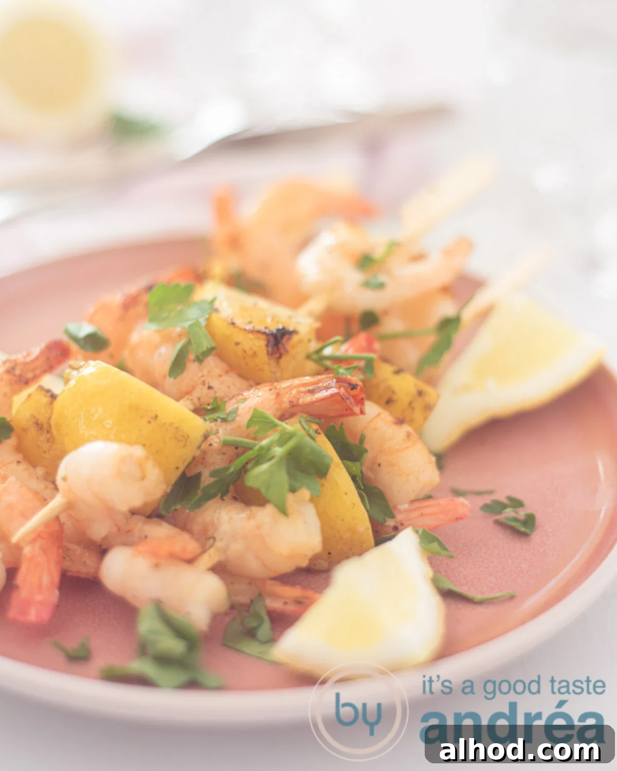 Grilled Lemon-Garlic Shrimp Skewers 5 Lemon Garlic Shrimp Kabobs on a pink platter, sprinkled with parsley. A white background