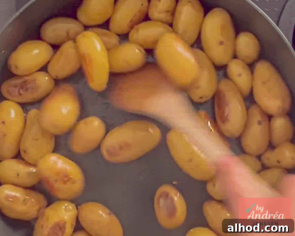 Golden Skillet Chicken with Crispy Bacon and Potatoes 3 Crispy baby potatoes sizzling in butter and olive oil in a pan, seasoned perfectly, forming the flavorful base for the chicken skillet.